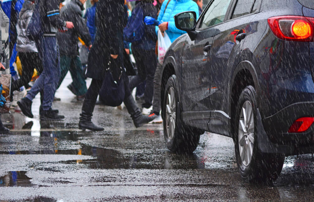 Vehicle skids in rain and hits pedestrian
